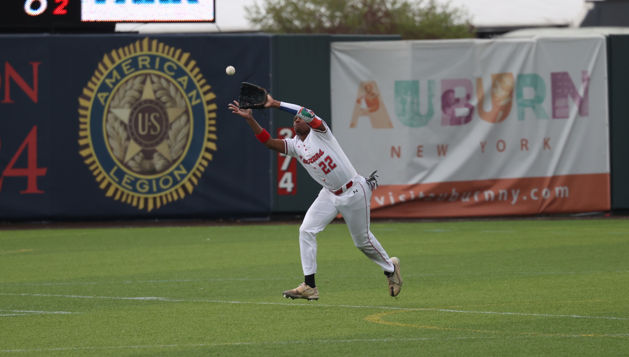 A Cayuga Community College Baseball outfielder prepares to catch a fly ball.