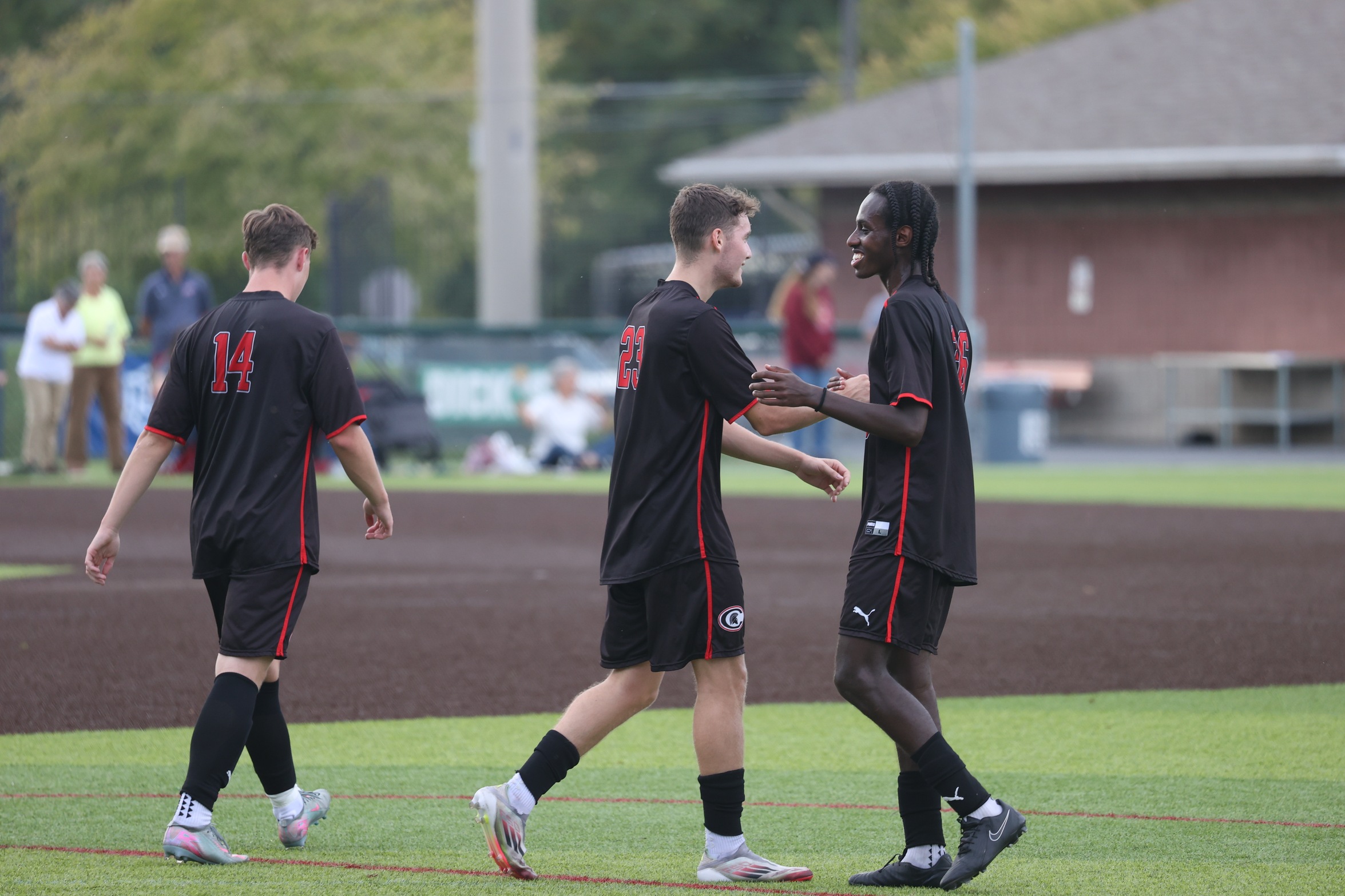 Three Cayuga players celebrate. 